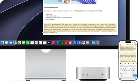 Mac mini front, tucked under Studio Display, an iPhone sits to the right of the device and the display, text selected with cut, copy, paste, and AutoFill commands above on iPhone matches highlighted text on display, showcasing Universal Clipboard