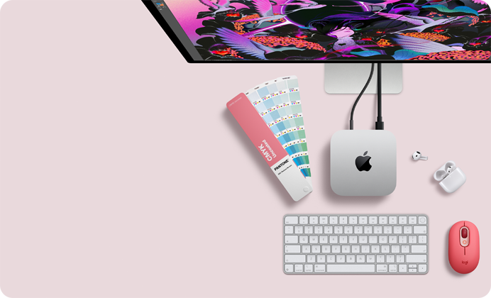 Mac mini, top, silver aluminum, rounded corners, glossy black Apple logo centered, connected by cord, Studio Display partially visible on top, AirPods 4, open, Pantone color swatches, Magic Keyboard, and mouse