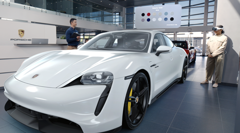 A customer in a Porsche showroom views a realistic 3D projection of a white sportscar with Apple Vision Pro and talks with an employee about color options displayed above the car