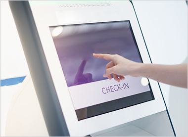 patient using a self-service kiosk to check in at a clinic